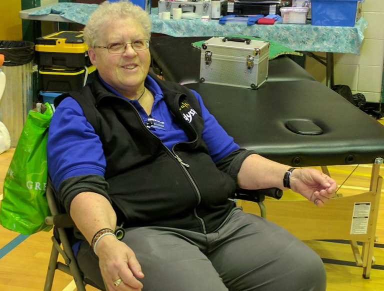 Alice Dennis, sitting on the sidelines, smiling