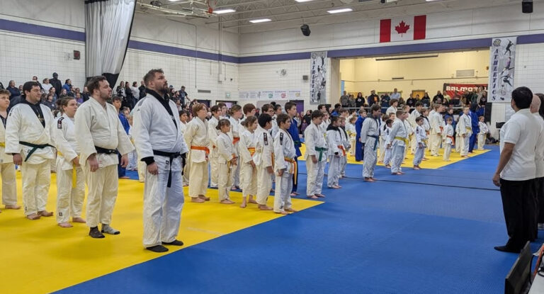 Athletes and referees on the mat, preparing for the bow-in